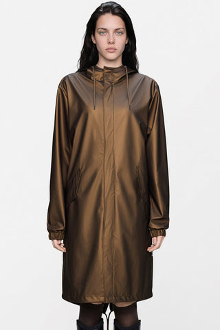A woman wearing a metallic bronze-brown hooded raincoat against a plain white studio background.