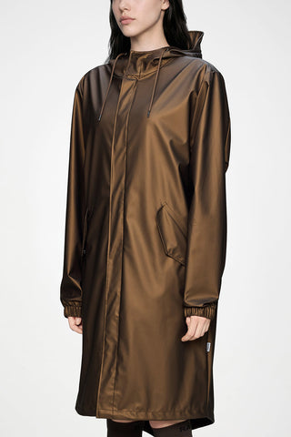 A woman wearing a metallic bronze-brown hooded raincoat against a plain white studio background.