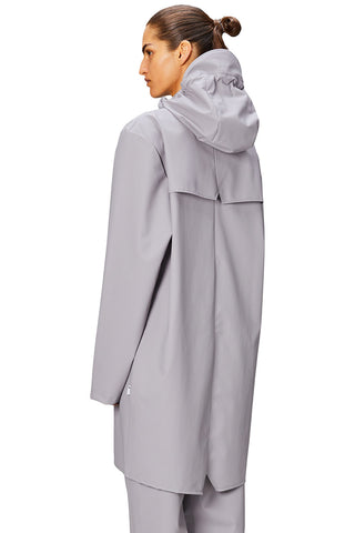 Side view of woman wearing grey flint coloured waterproof Long Jacket by Rains. 