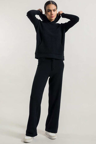 Model wearing black recycled cashmere Fiona sweater by Rifo. 