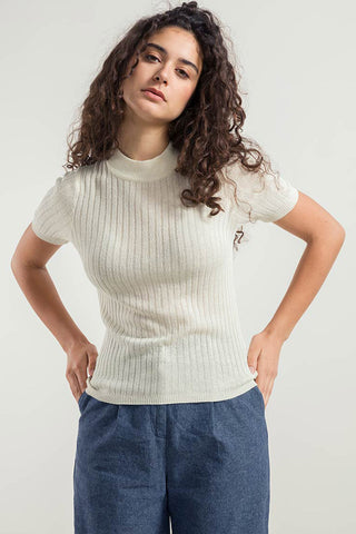 Woman wearing white recycled ribbed short sleeve Renza sweater by Rifo. 