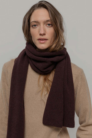 Woman in front of grey background wearing beige knit sweater and coffee brown knit Federico Scarf by Rifo. 