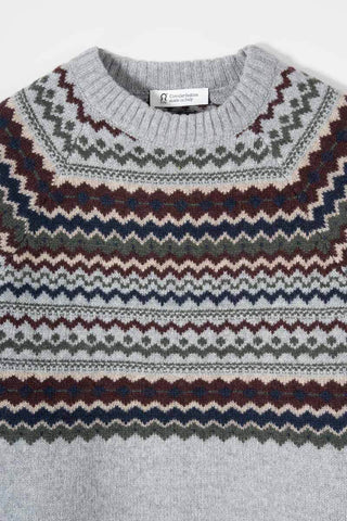 A close-up of a knit crewneck sweater with a gray base and intricate Fair Isle patterns in navy blue, burgundy, olive green, and cream.