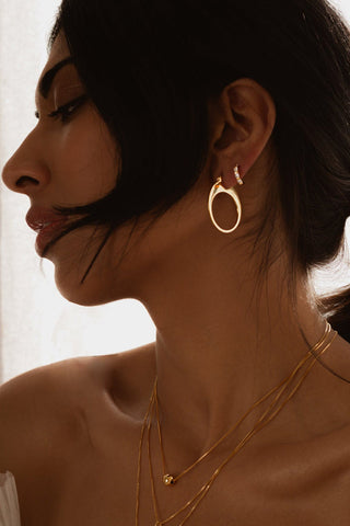 Model wearing Sarah Mulder gold Solange Hoop Earrings. 