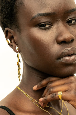 Model wearing gold Bidu Dangle Earrings by Soko. 