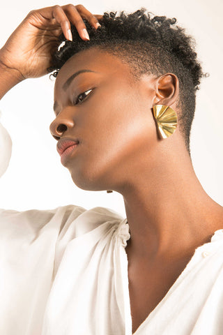 Model wearing gold Bidu Fanned Stud earrings by Soko. 