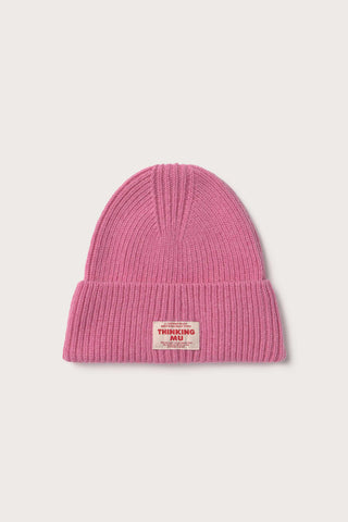 Flat lay photo of pink wool rib knit Amor beanie by Thinking Mu. 