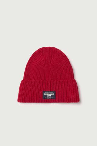 Flat lay photo of red wool rib knit Amor beanie by Thinking Mu. 