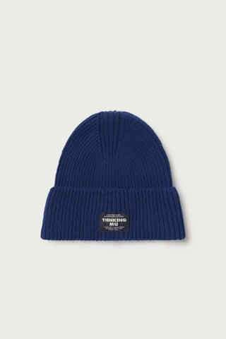 Flat lay photo of blue wool rib knit Amor beanie by Thinking Mu. 