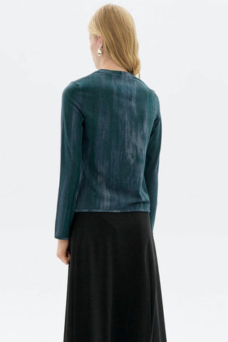 Back view of woman in front of white background wearing blue organic cotton ombre print Brisa long sleeve top by Thinking Mu. 