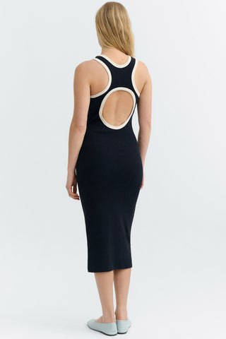 Back view of woman wearing navy sleeveless midi length dress with but out detail on back. 