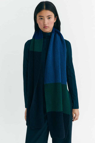 Model wearing blue sweater & pants with long blue & green stripe Ghedes scarf by Thinking Mu. 