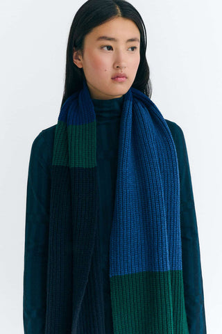 Model wearing blue sweater & pants with long blue & green stripe Ghedes scarf by Thinking Mu. 