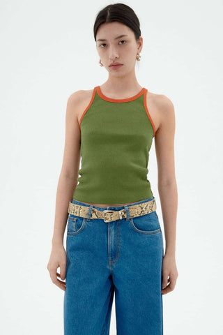 Woman wearing jeans and green tank top with orange trim. 