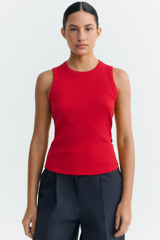 Woman wearing red ribbed tank top with navy pants. 