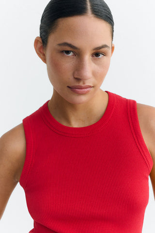 Close-up of woman wearing red ribbed tank top. 