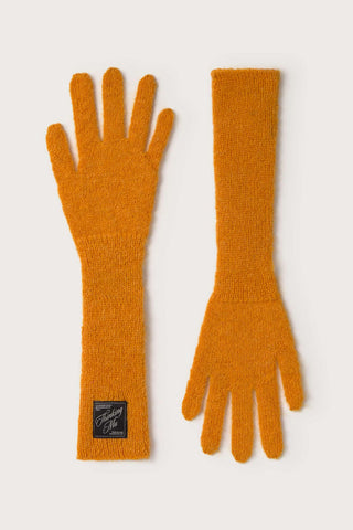 Flat lay image of orange knit Maggie gloves by Thinking Mu. 