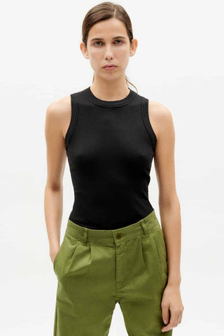 Woman wearing black organic cotton Juliette tank top by Thinking Mu. 