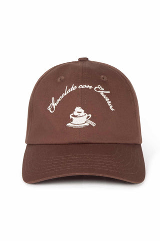 A brown baseball cap with white embroidered text reading 'Chocolate con Churros' and a small coffee cup, shown against a plain white background.