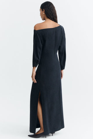 A woman shown from the back wearing a long, off-the-shoulder black full length dress with long sleeves, photographed against a clean white studio background.