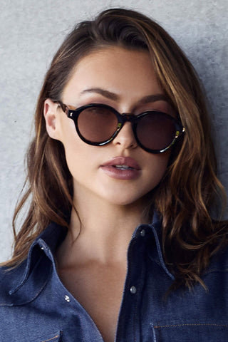 Model wearing Valley Eyewear Motel Sunglasses in tortoise with light brown lenses. 