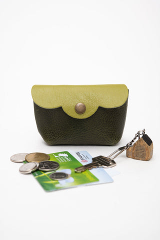 Lime green and dark green leather coin pouch shown with coins, metro card & keys. 