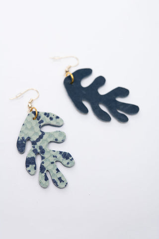 Coral shaped leather earrings on white background, one shows front with two tone blue snake print, the other shows back with solid blue suede. 
