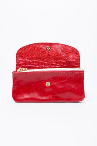 Red leather wallet with brass snap closure, open, showing zippered pocket inside. 