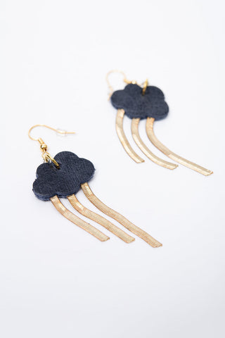 A pair of cloud-shaped drop earrings with dark navy leather cloud with three dangling gold-tone chains, shown on a clean white background.