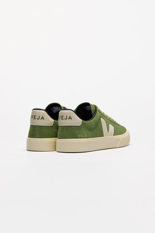 Back view of a pair of Kiwi + Pierre Veja Campo Suede shoes against a white background. Body of shoe is kiwi green suede, Veja V logo is Pierre cream. 