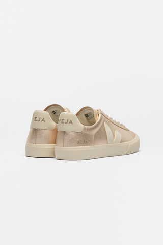 A pair of low-top sneakers in a metallic rose gold leather with Veja V logo in cream, shown from the back against a plain white background. 