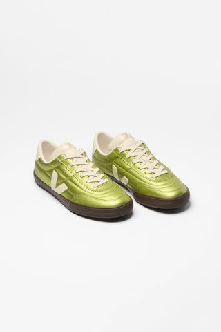 A pair of low-top sneakers in metallic green with cream-colored laces, tongue, and Veja V side logo, and dark brown soles, photographed on a clean white background.