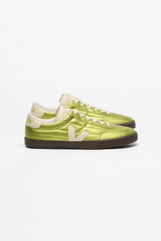 A pair of low-top sneakers in a metallic lime green colorway, featuring cream-colored 'V' logos on the sides, cream laces, and dark brown soles, shown against a plain white background.