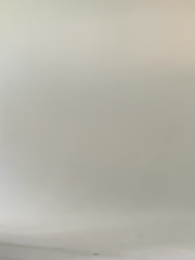 Woman walks across the screen wearing green knee length summer dress. 