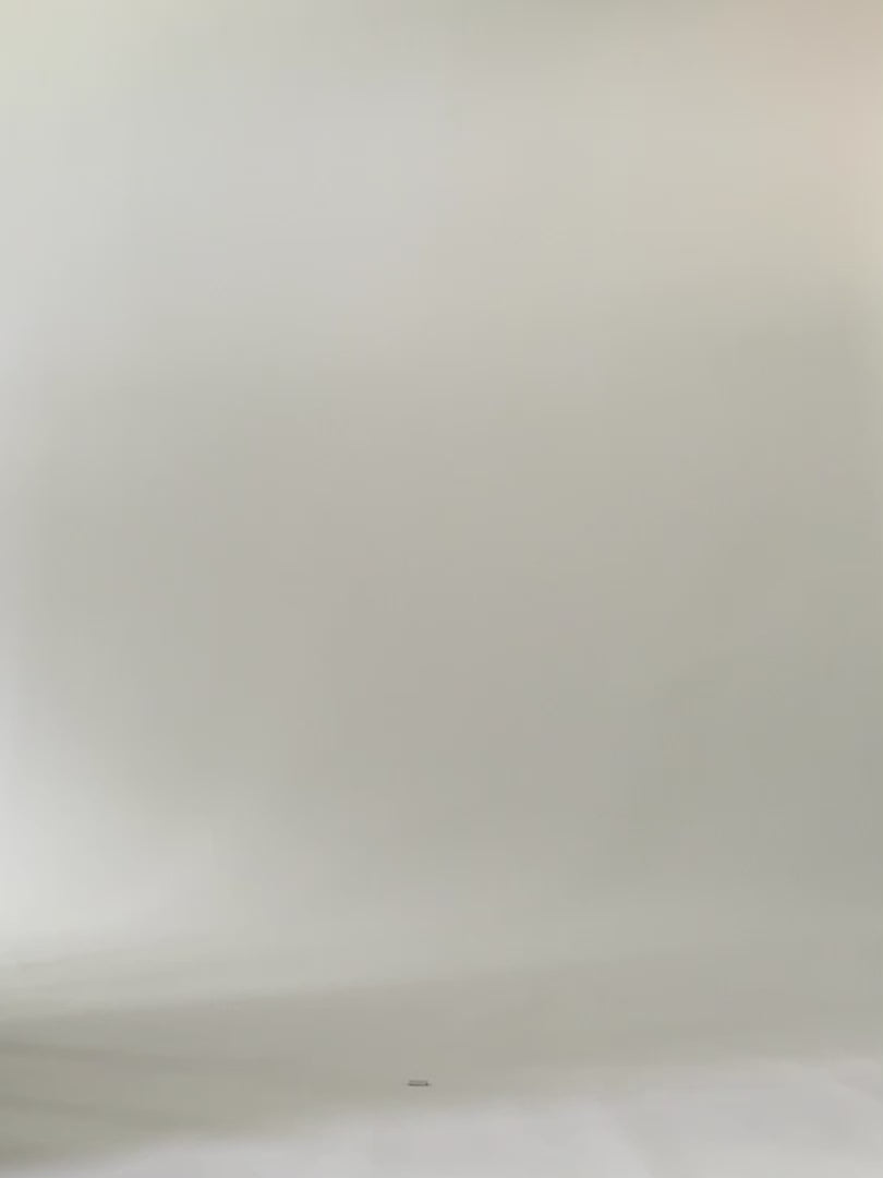 Woman walks across screen wearing black and white colour block tunic. 