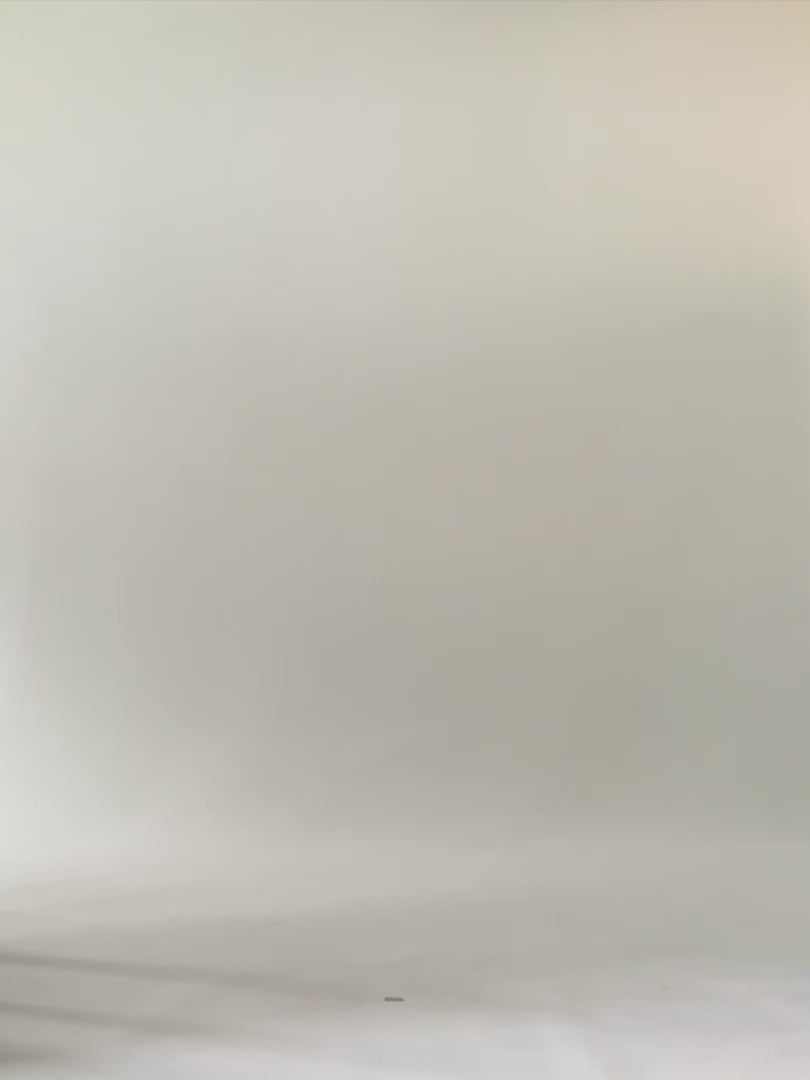 Woman in studio wearing stripe tank top, blue pants and black sneakers. 