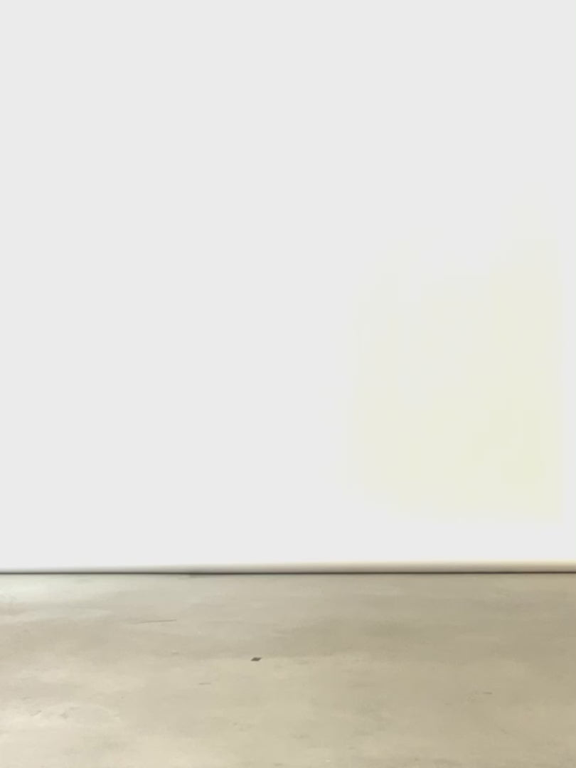 A woman walks across the screen in neutral studio wearing dual tone colour blocked denim tunic dress and black boots. 