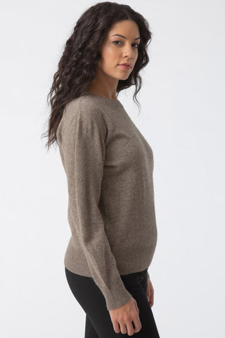 Side view of model wearing oat brown Yak wool O-Neck sweater by Dinadi. 