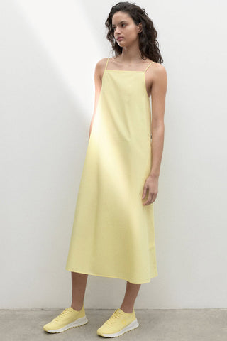Model wearing yellow organic cotton Perla dress by Ecoalf. 