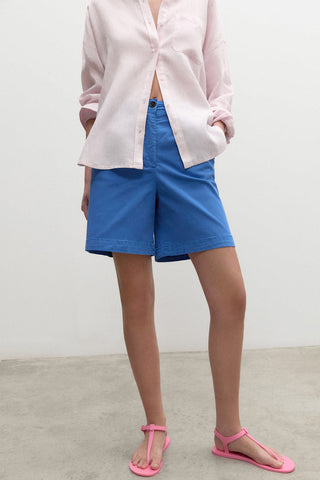 Model wearing blue high waist organic cotton Po Shorts by Ecoalf. 