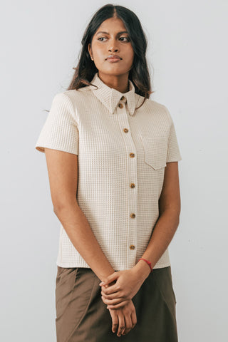 Model wearing Jennifer Glasgow Asherah Button Up in cream organic cotton waffle weave. 
