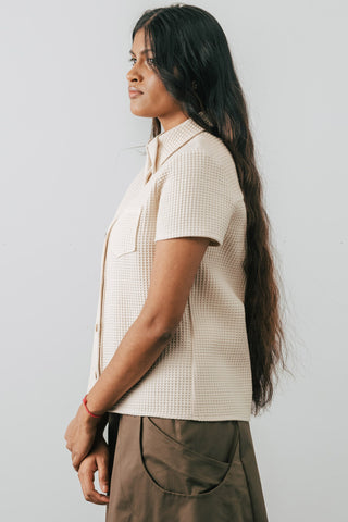 Side view of model wearing Jennifer Glasgow Asherah Button Up in cream organic cotton waffle weave. 