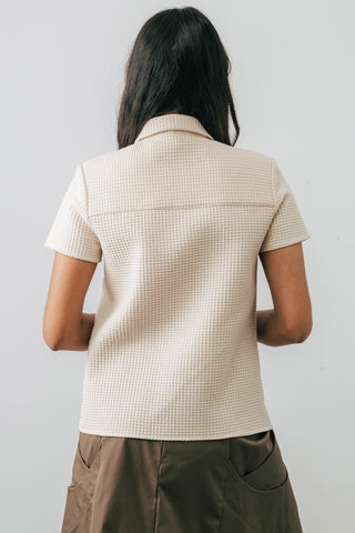 Back view of model wearing Jennifer Glasgow Asherah Button Up in cream organic cotton waffle weave. 