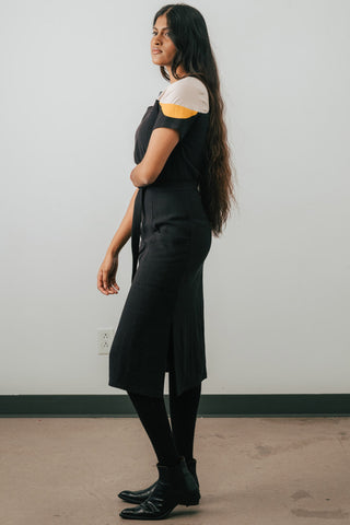 Side view of model wearing Jennifer Glasgow Meri Dress in black linen blend. 