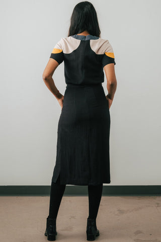 Back view of model wearing Jennifer Glasgow Meri Dress in black linen blend. 