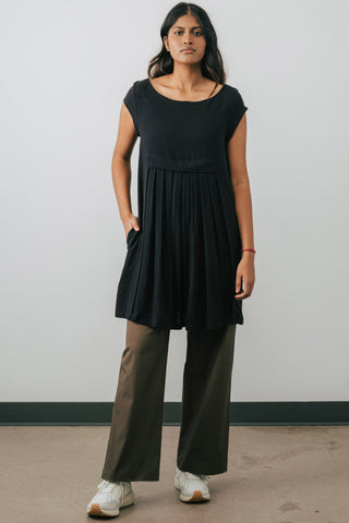 Model wearing Jennifer Glasgow Saiwa pleated dress in black OEKO-TEK linen blend.