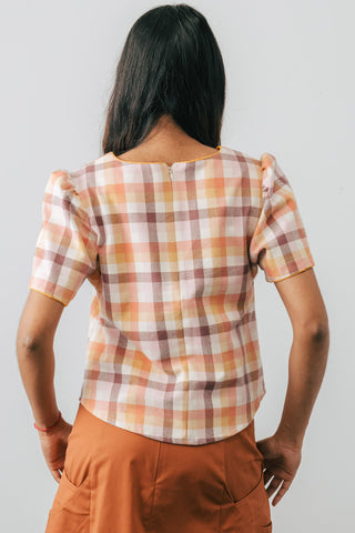 Side view of model wearing Jennifer Glasgow Samudra pink plaid blouse in GOTS certified organic cotton. 