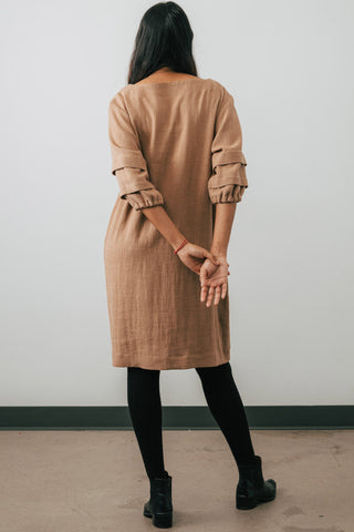 Model wearing Jennifer Glasgow Shui tunic dress in camel OEKO-TEK linen blend. 