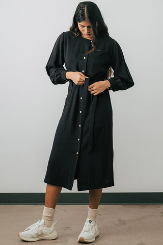 Model is wearing black midi length button up Umiko shirt dress by Jennifer Glasgow. 