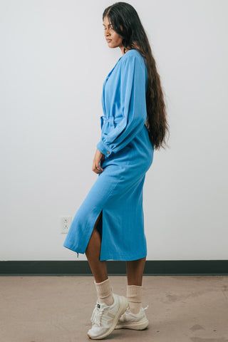 Side view of model is wearing blue midi length button up Umiko shirt dress by Jennifer Glasgow. 
